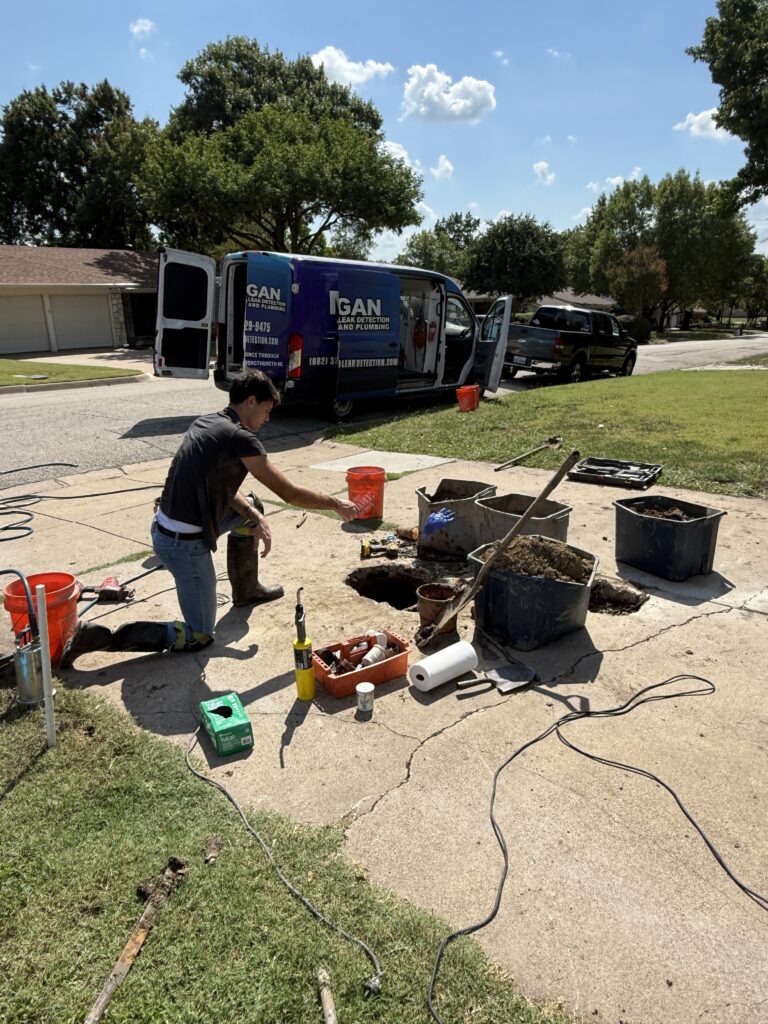 Technician performing non-invasive slab leak repair on a residential driveway in Dallas-Fort Worth.