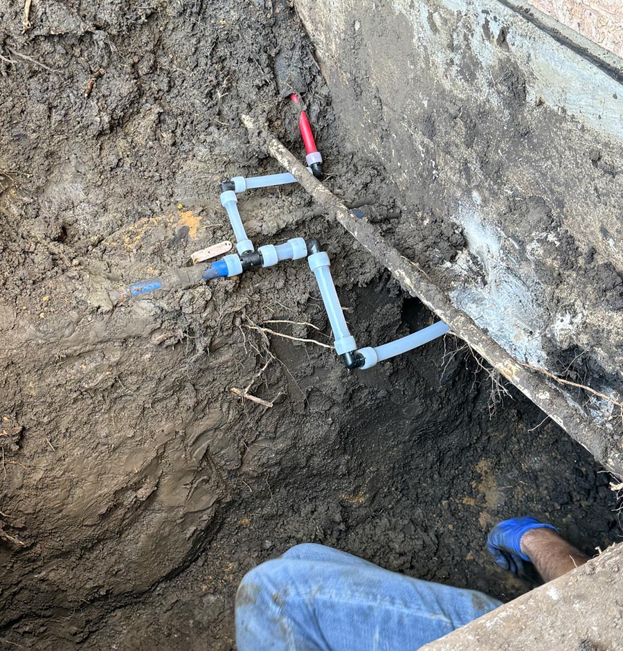 Close-up of a slab leak reroute using PEX piping beneath a home foundation in Dallas-Fort Worth.